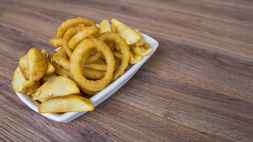 A golden plate of crispy onion rings, perfectly battered and ready to be enjoyed on National Onion Rings Day.